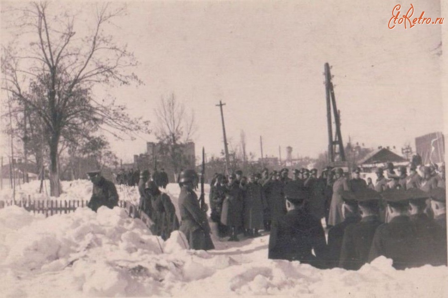 Коростень - Торжественная церемония немецких оккупантов на немецком братском кладбище в Коростене. На заднем плане здание Коростенского медицинского техникума, сейчас Коростенская городская поликлиника. Зима 1941-1942 г.