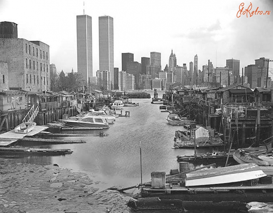 Нью-Йорк - The ramshackle Greene Street Boat Club in Jersey City on the Morris Canal Small Basin graced by the World Trade Center across the Hudson River. США,  Нью-Джерси