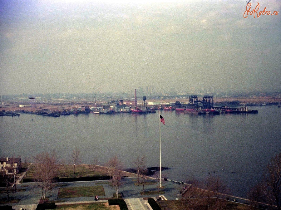 Нью-Йорк - Abandoned swampland, industrial and railroad ruins line the waterfront as seen from the Statue of Liberty. США,  Нью-Йорк (штат),  Нью-Йорк,  Манхеттен