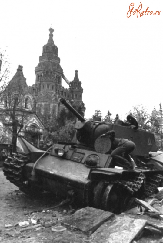 Войны (боевые действия) - Немецкий солдат осматривает подбитый в Петергофе танк КВ1.
