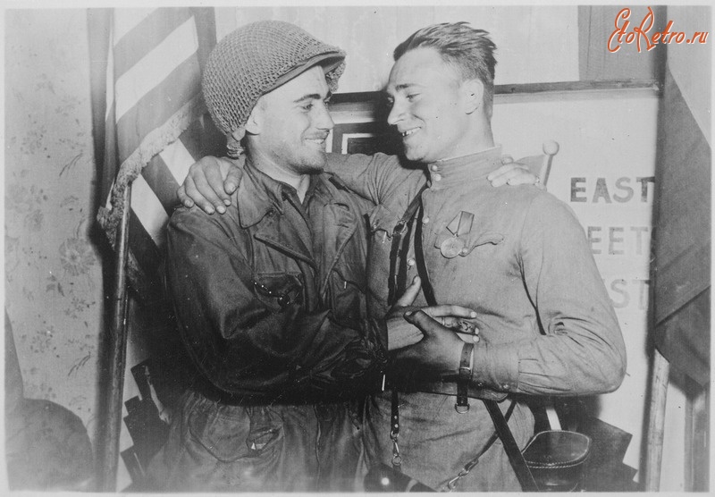 Войны (боевые действия) - 2-й лейтенант У. Робертсон и лейтенант А. С. Сильвашко на фоне надписи «Восток встречается с Западом»