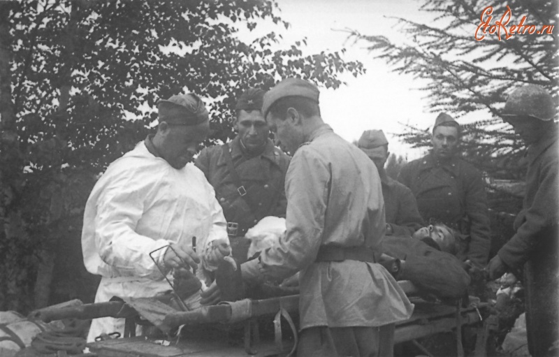 Войны (боевые действия) - Старший лейтенант Постригонь оказывает помощь раненому бойцу во время Южно-Сахалинской наступательной операции. Август 1945