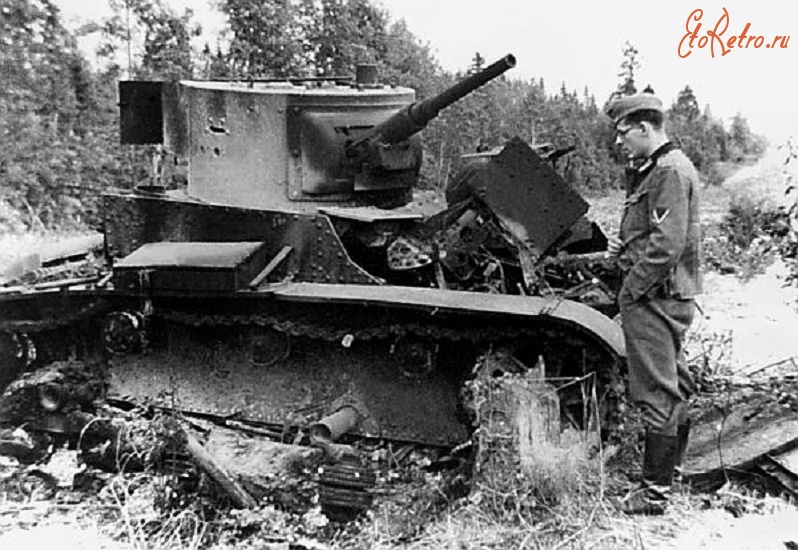 Военная техника - Немецкий солдат осматривает разбитый танк Т-26. Группа армий «Центр», июнь 1941 года