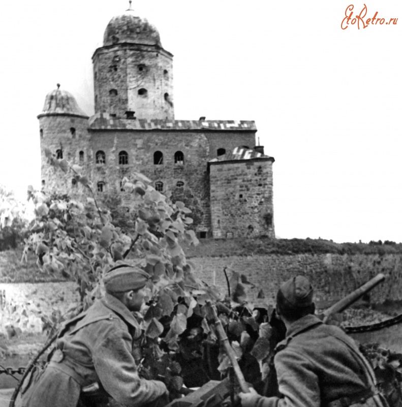 Выборг - Советские солдаты в Выборге на фоне выборгского замка с замаскированной 45-мм противотанковой пушкой.