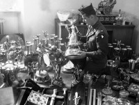 Германия - Лейтенант американской армии рассматривает золотую статуэтку из коллекции Германа Геринга