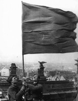Берлин - Советские солдаты водружают знамя над Рейхстагом 2 мая 1945 года. Это одно из знамен, установленных на Рейстаге помимо официального водружения знамени Егоровым и Кантария.