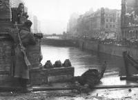 Берлин - Советский солдат осматривает местность на мосту реки Шпрее в Берлине. Рядом предположительно лежит труп советского танкиста.