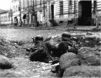 Харьков - Немецкие пулеметчики с пулеметом MG-34 лежат в укрытии, возможно в воронке от снаряда или бомбы, на улице Харькова.