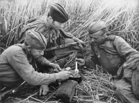 Солдаты и офицеры Советской армии - Трое советских солдат-гвардейцев, вооруженных ППШ, едят из одного котелка.