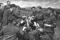 Войны (боевые действия) - Советский лейтенант раздает сигареты немецким военнопленным под Курском, июль 1943 года.